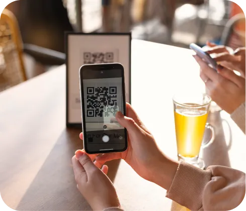 Manos usando celular para scanear un QR para  pagos en Poket