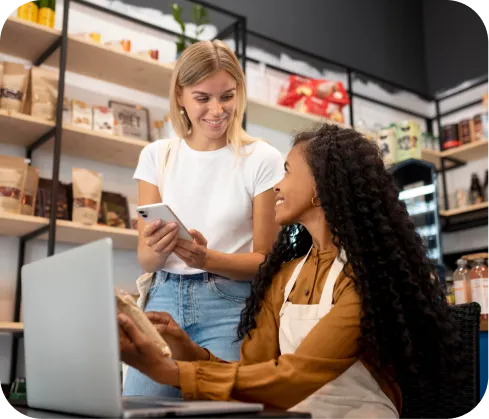 Mujeres emprendedoras usando celular para cobrar con Poket