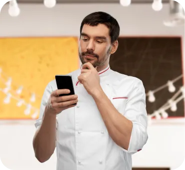 Hombre sonriente en una cafetería usando celular para cobrar con Poket